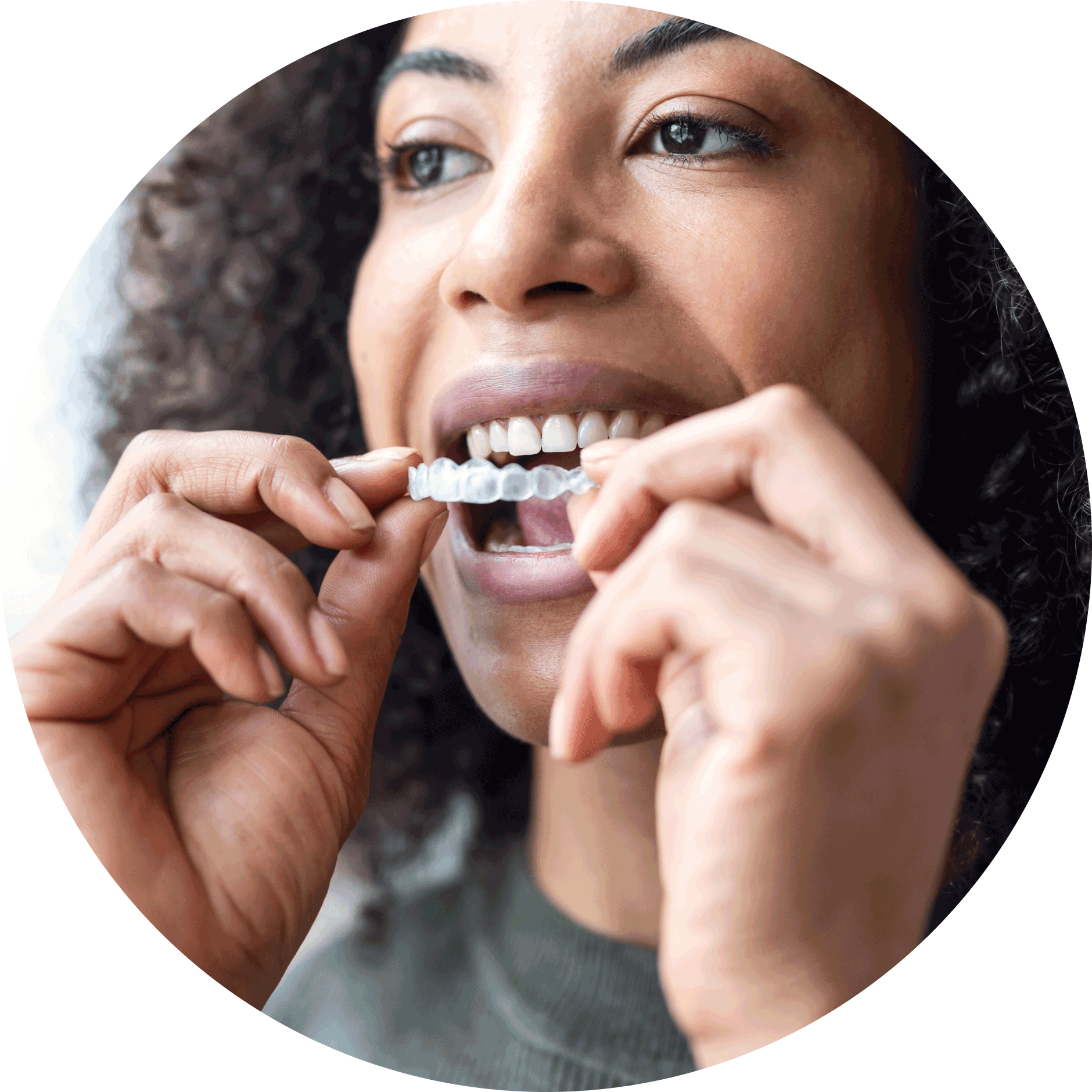 african american woman placing invisalign aligner on teeth